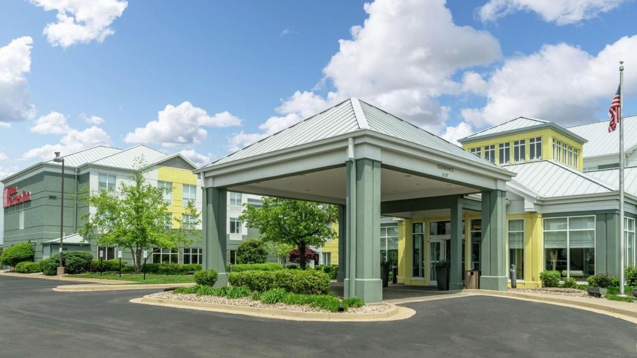 Hilton Garden Inn Louisville East, a 122-key hotel in Kentucky, under a partly cloudy sky, acquired by HBS Investment Group in March 2025, near the University of Louisville and Kentucky Derby attractions