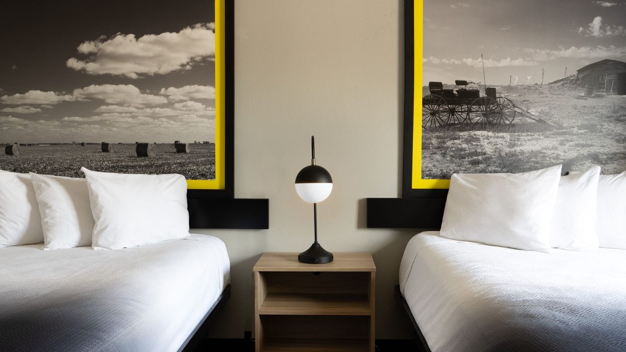 Modern Super 8 guestroom featuring INNOV8TE 2.0 design with lighter case goods, red accents, and hyper-local headboard art