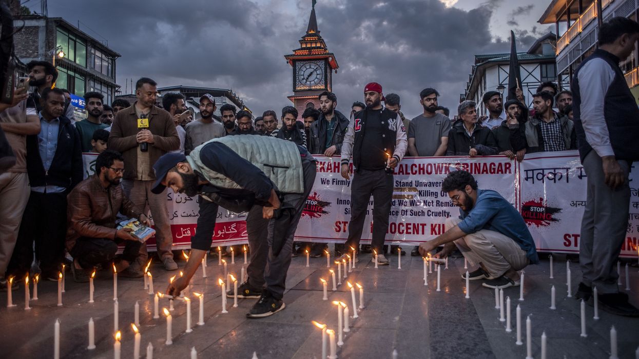 Protesters light candles at a vigil in Srinagar, holding banners reading 'Kahchow Binagar' and 'Stop Innocent Killing,' mourning the 2025 Pahalgam terror attack