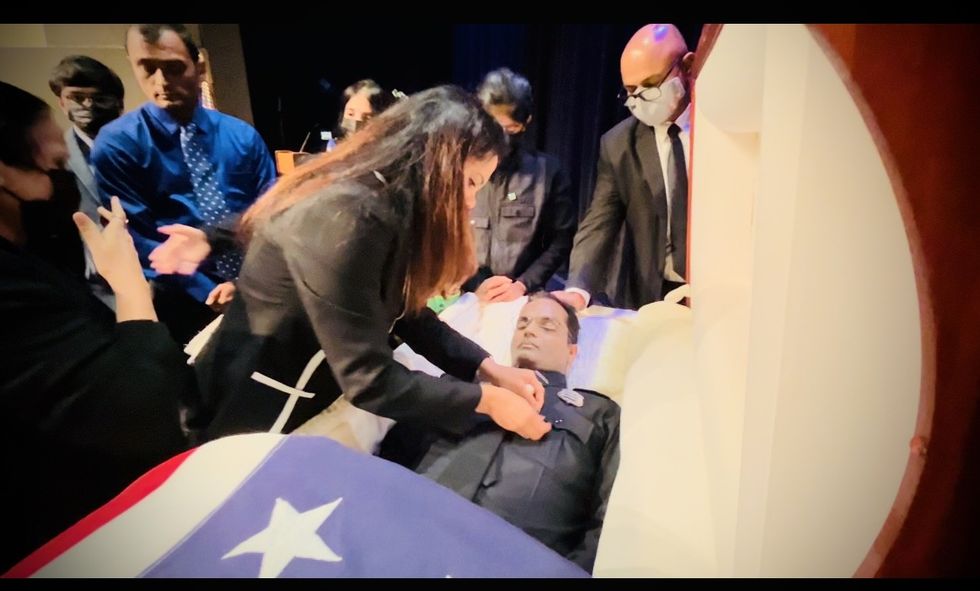 Sister pins lapel of brother