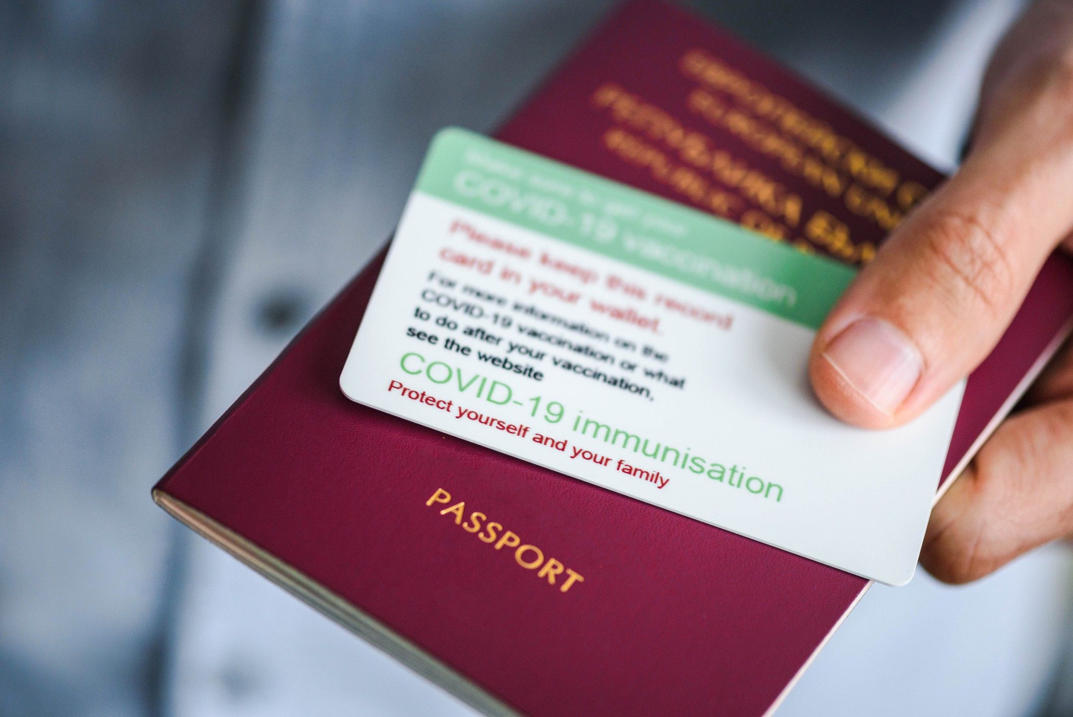 Vaccination card / ID for Covid 19 immunization and a passport close up photo. Coronavirus pandemic concept. Vaccination ID card close up.