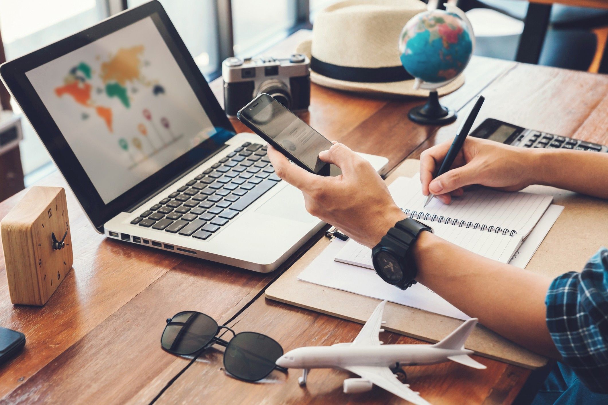 Young men planning vacation trip and searching information or booking an hotel on a smart phone and laptop.travel , trip vacation, international travel