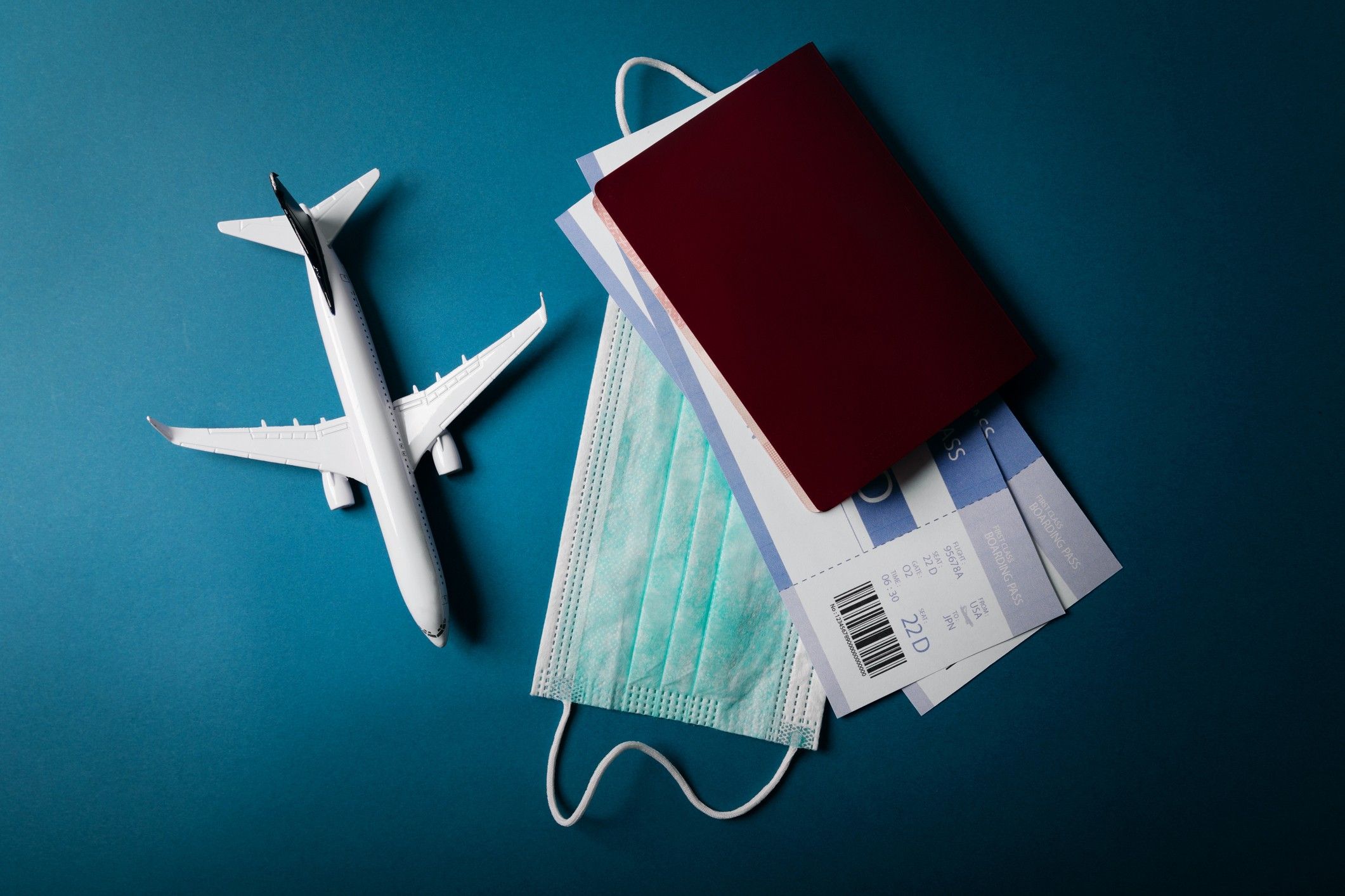 travel during the covid-19 pandemic. airplane model with face mask and travel documents Mask mandate for public transportation