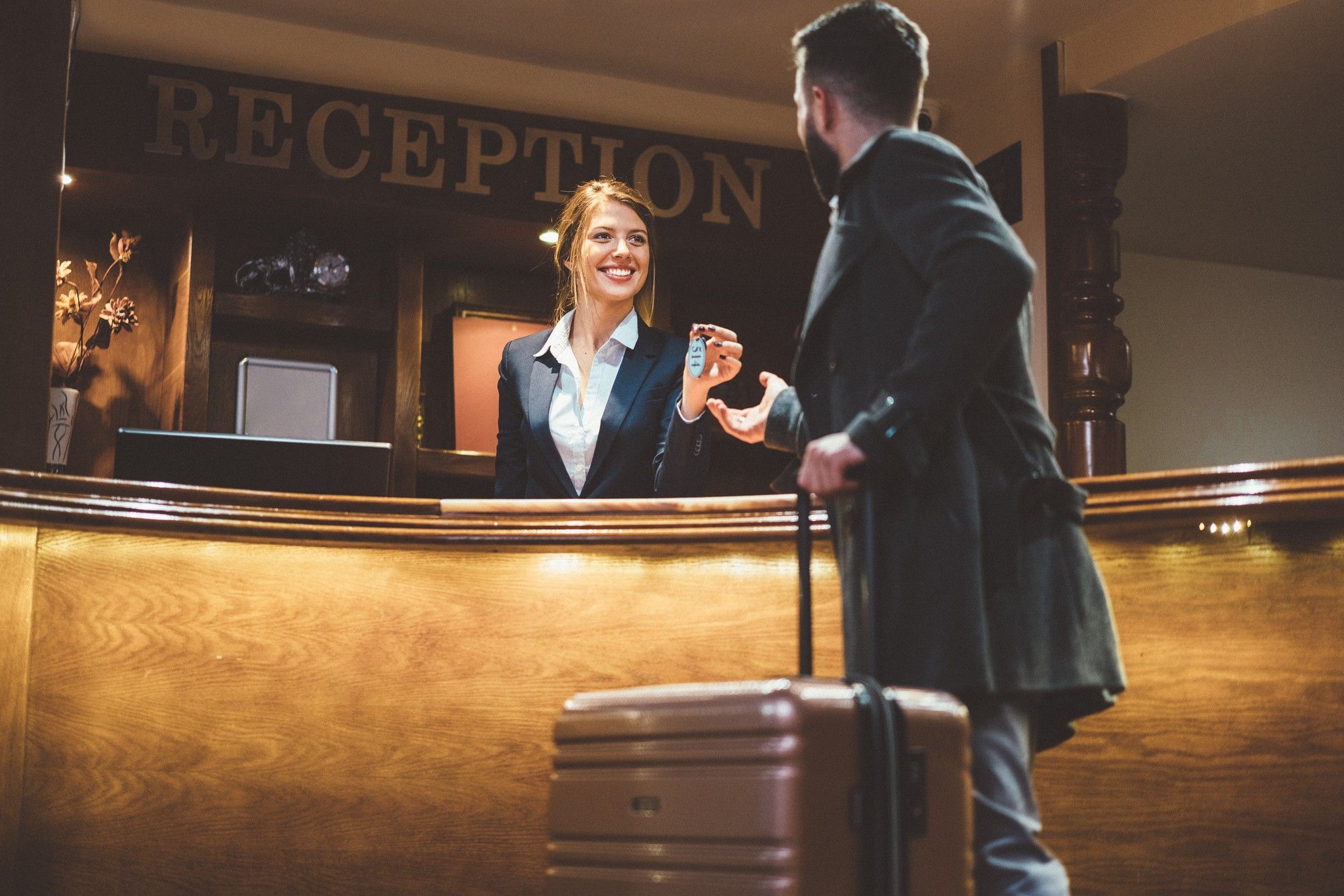 Receptionist giving keys to hotel guest USTA