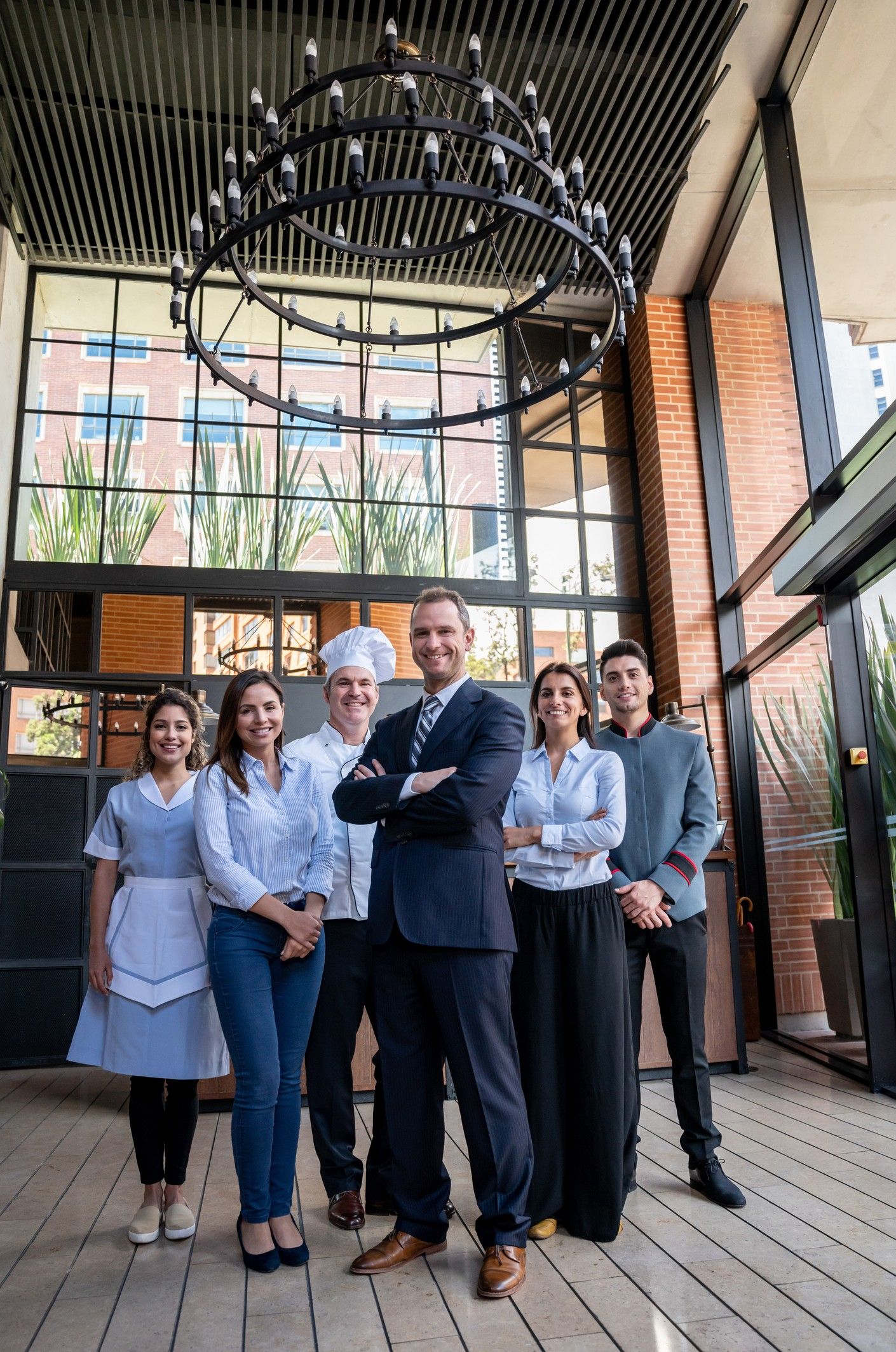 Latin american confident luxury hotel staff all facing camera smiling AHLA strategic partnership